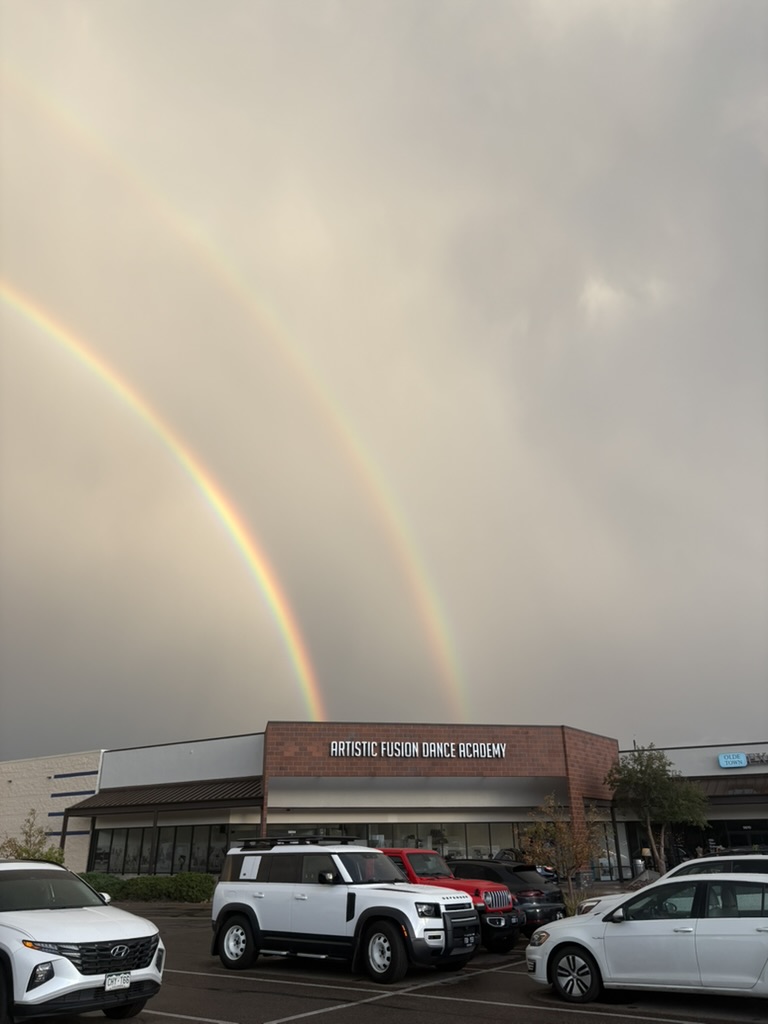 The Artistic Fusion Dance Academy storefront beneath a double rainbow